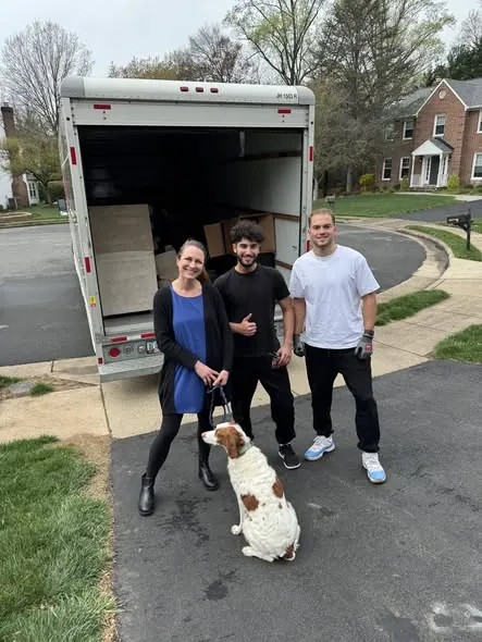 Crew with a customer and her dog beside the loaded truck on a Northern Virginia street